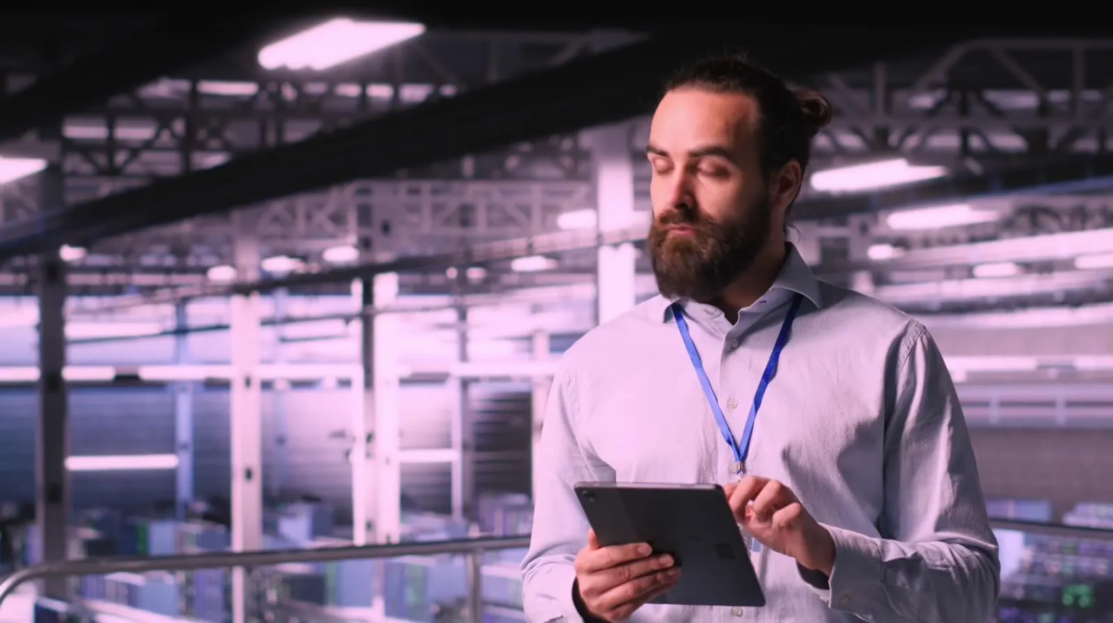 Technische Fachkraft prüft Daten auf einem Tablet in einer Produktionshalle